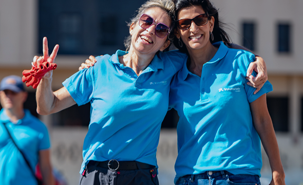 Two girls wearing CaixaBank volunteer t-shirts