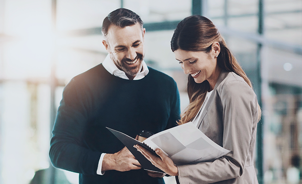 Boy and girl smiling while looking at documents